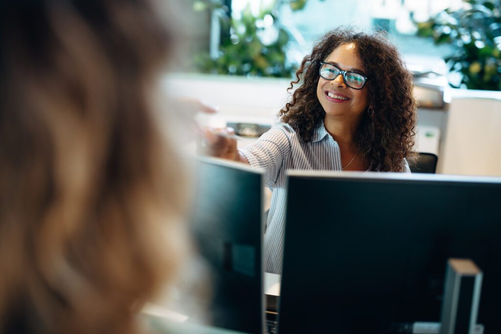 Female,Receptionist,Helping,A,Woman,Visitor,At,Front,Desk.,Administrator